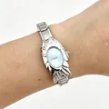Close-up of a unique fish-shaped silver metal watch with light blue dial worn on a wrist - 5469-Silver Blue