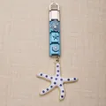 Detailweergave van een blauwe Italiaanse bedelhanger met een witte blauwgestippelde zeester - Blauwe Schelp Zeester Serie (1)