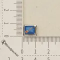 Detail view of a Halloween broomstick pattern on a blue stainless steel charm link - Broom Pattern (1)