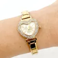Detail shot of a luxury gold heart-shaped watch with rhinestone bezel on a wrist. - Heart Butterfly Pattern (5223) / Gold (5223-Gold White Dial)