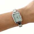Detailed shot of a classic silver steel band quartz watch for women on a human wrist - Silver Square Dial Mint Green