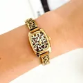 Close-up of a women's gold quartz bracelet watch with a leopard print dial on a wrist - Leopard Square Dial Style / Gold