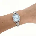 Gros plan d'une montre carrée argentée pour femme avec cadran bleu clair et strass brillants - Argent, Bleu Clair