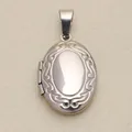 Detailed macro view of vintage engraved silver polished oval locket jewelry pendant - Carved Oval / Silver