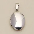 Macro view of a vintage polished silver oval locket pendant with a smooth mirror finish - Mirror Polished Oval / Silver