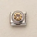 Dettaglio macro di charm italiano con una grande pietra preziosa rotonda color ambra - Marrone