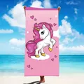 Rosa Mikrofaser-Strandtuch mit niedlichem Einhorndruck vor sonnigem Tropenstrandhintergrund. - Einhorn