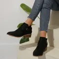 Elegant black pointed toe Chelsea boots featuring cross strap buckle and chunky mid-heel - Black