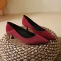 Detailed shot of burgundy suede pointed-toe kitten heel pumps on a rustic woven stool. - 35 / Burgundy