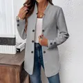 Detailed view of women's gray textured blazer with stand collar and button accents - S / Tops / Gray