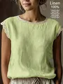 Primo piano di camicetta verde chiaro 100% lino con dettaglio in pizzo bianco sullo scollo - Taglia S / Top / Verde chiaro
