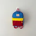 Detailed view of a colorful kids' backpack hanging on a minimal grey wall. - One Size / Blue