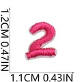 Close-up detail of mini pink number 2 embroidered patch showing 1.2x1.1cm dimensions. - Number 2