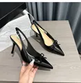 Primo piano di eleganti décolleté slingback in vernice nera con dettaglio a fiocco. - 38 / 6.5cm Altezza Tacco / Nero