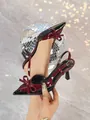 Detail of burgundy patent leather pointy high heels with bow and slingback design. - 34 / Black + Wine Red