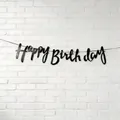 Elegant black Happy Birthday scripted banner hanging on white brick wall background - Cursive Letter Style / Black