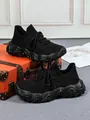Bequeme schwarze Fly-Knit-Sportschuhe für Damen mit weiß gesprenkelten Wellensohlen - Schwarz