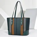 Front view of large capacity striped tote bag with teal leather handles and accents - 35x12x25cm / Green