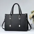 Elegante bolso de mano negro en cuero granulado con herrajes plateados y asas - Negro