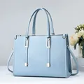 Bolso de mano en cuero azul claro texturizado con herrajes dorados y correa larga - Azul cielo