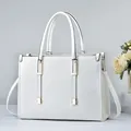 Elegante bolso de mano blanco en cuero granulado con herrajes dorados y una correa - Blanco Roto