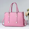 Elegante bolso de mano rosa en cuero granulado con herrajes dorados y bandolera - Rosa