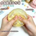Primo piano di una pallina antistress in slime di cristallo giallo glitterato tra le mani. - Stile sfera croccante di cristallo / 1 Pezzo / Sfera croccante di cristallo--Giallo