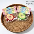 Detailed view of fruit-shaped stress relief pinch toys in their colorful packaging - Small Apple / Random Color