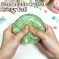 Dettaglio delle mani che premono un giocattolo antistress verde glitterato e lucido - Stile sfera croccante di cristallo / 1 Pezzo / Sfera croccante di cristallo--Verde