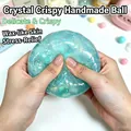 Primo piano di mani che schiacciano una pallina antistress in argilla di cristallo blu - Sfera Croccante di Cristallo / 1 Pezzo / Blu