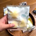 Close-up van een handgemaakt kaas-stress-knijpspeeltje in een zakje met een knapperige textuur. - Krokante Handgemaakte Tas-Kaas / Geel