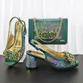 Detailansicht grüner Satinschuhe und passender Clutch mit elegantem Kristallbesatz - 41 / Grün