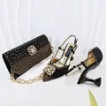 Detail von schwarzen Strass-Abendschuhen und passender Clutch-Tasche mit Blumendekor - 38 / Schwarz