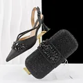 Detailed view of black glitter slingback heels and matching rhinestone clutch bag. - 37 / Black