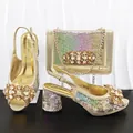 Nahaufnahme goldener schillernder High Heels mit passender Strass-Abendtasche - 40 / Gold