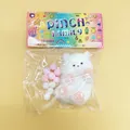 White cat squishy stress relief toy with pink paws in original colorful packaging - Dog