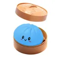 Nahaufnahme eines blauen Cartoon-Knödel-Stressspielzeugs in einem Mini-Dampfgarer. - Blauer Emoji-Stil (Mit Dampfgarer)