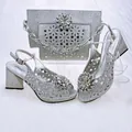 Silberne Glitzer-Sandalen mit Blockabsatz und passende Clutch-Tasche mit Strass-Schnalle - 38 / Silber