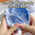 Gros plan d'un jouet anti-stress perlé bleu et blanc translucide en train d'être pressé - Avec Outil de Pompe à Air / Surdimensionné / Bleu