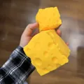 Detailansicht eines übergroßen gelben Schweizer Käse-Squishy-Spielzeugs zum Stressabbau - 5x5 Käseblock