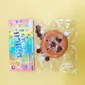Detail view of a brown squishy stress relief toy in colorful packaging - Round Capybara