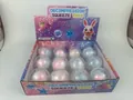 Detail view of 12-piece box of colorful decompression squeeze squishy toys in capsules - Crackle Rainbow Ball