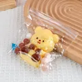 Yellow cartoon bear squishy stress relief toy presented in a clear zipper bag with pom poms - Butter Bear