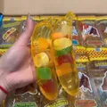 Nahaufnahme von transparentem Bananen-Quetschspielzeug mit bunten Fruchtfüllungen - Malzzucker-Textur / 1 Stück Assortierte Frucht Gelee Banane