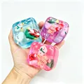 Close-up of colorful Christmas themed stress relief squishy cubes with snowman and tree - Box Packaging / Christmas Green