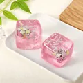 Detail van schelpen en sterglitters in roze doorschijnende knijpspeelgoed kubus. - Zakverpakking / Roze