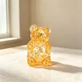 Macro view of a translucent amber bear squishy stress relief toy with gold glitter flakes - Glitter Maltose Bear (Yellow)