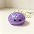 Primer plano de un juguete squishy con forma de empanadilla morada brillante y cara linda. - Fantasma del Diablo