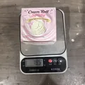 Cream roll squishy decompression toy being weighed on a digital scale showing 185g mass - 1 Piece/Pack / Cream