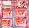 Set of pink faux crisp chocolate squishy toys in individual clear storage boxes. - Pink Chocolate Crisp